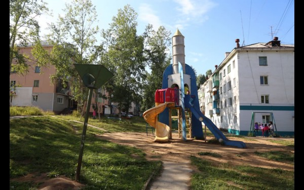 Игровое сооружение в виде ракеты на детской площадке.