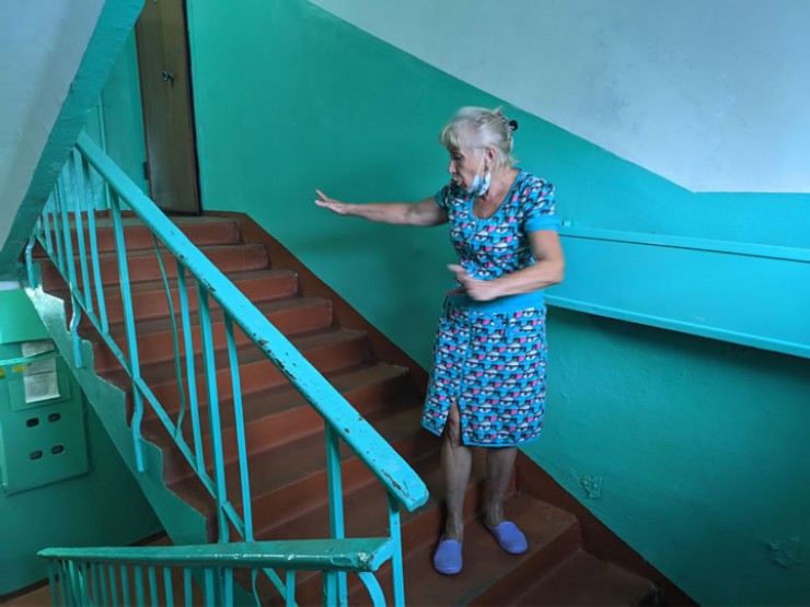 Соседка убитых Татьяна Гусева показывает место, где произошла трагедия. По ее признанию, после случившегося у нее каждый раз немеют ноги, когда она выходит на лестницу.