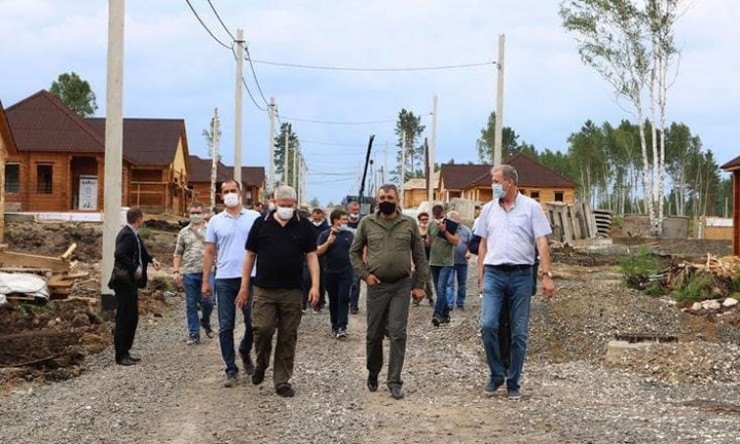 Полпред президента Сергей Меняйло (второй справа в первом ряду) остался недоволен качеством работ в Тулуне и слабым контролем их выполнения. В частности, он обратил внимание на плохо уложенный асфальт. Претензии были и при осмотре квартир в одном из готовых домов, в частности, к отделочным работам.