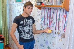 Анатолий показывает свои спортивные награды. Он занимается легкой атлетикой, бегает дистанции 100 и 400 метров, также он отлично играет в волейбол