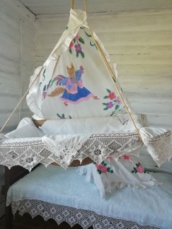 В белорусской избе царят порядок и уют. Кровать застелена матрасом и подушками, набитыми соломой. Люлька украшена балдахином со сказочной вышивкой.
