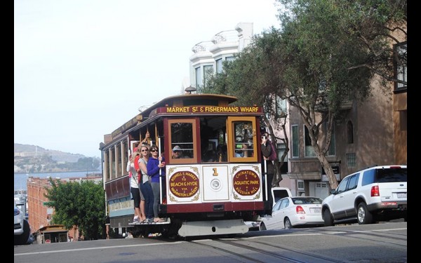 Знаменитый канатный трамвай (cable car), проезд на котором стоил нам с мужем по $7 с каждого. Водитель этого старинного (с 1873 года!) транспортного средства стоит в самом конце вагона, ворочает огромный рычаг-тормоз, деньги не разменивает  и сдачи не дает. А еще он, по желанию пассажиров, объявляет остановки